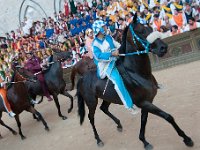 DSC 8447  Palio di Siena Zawodnicy dosiadający koni podczas gonitwy Palio reprezentują 17 dzielnic contrade. W samej gonitwie bierze udział 10. dżokejów (i fantini) reprezentujących kontrady, jak też 10 koni wystawionych przez te dzielnice. Tymczasem o wyborze kontrad, jak też koni i jeźdźców, którzy wezmą udział w gonitwie decyduje dość szczególne losowanie, zależne od przebiegu poprzedniej gonitwy Palio. Każda z drużyn biorących udział w gonitwie wystawia zatem swojego konia, jednak konie te są następnie losowane przez kontrady, co czyni gonitwę tym bardziej emocjonującą.